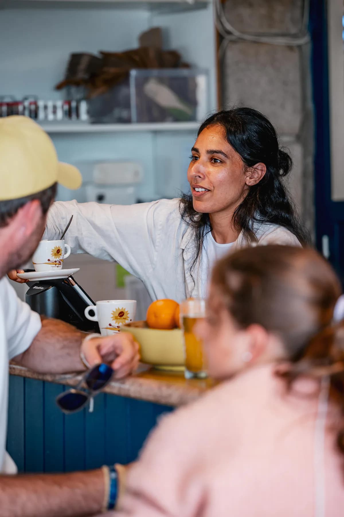 Une gérante discute avec des clients au comptoir
