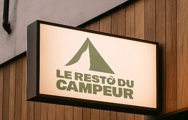 Enseigne lumineuse Le Resto du Campeur sur une façade en bois